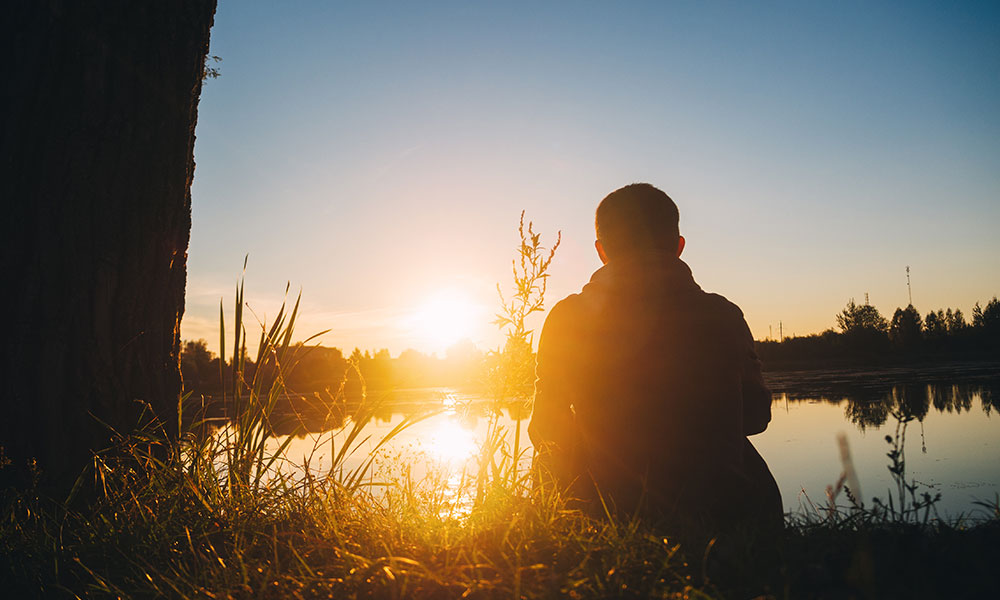 man sunset lake