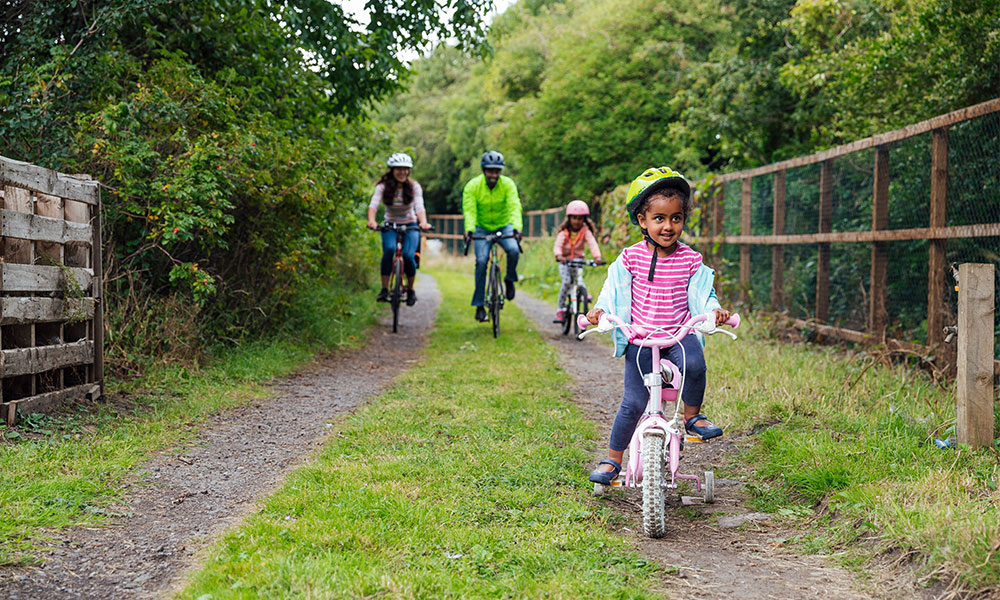 family cycling outdoors locally&nbsp;
