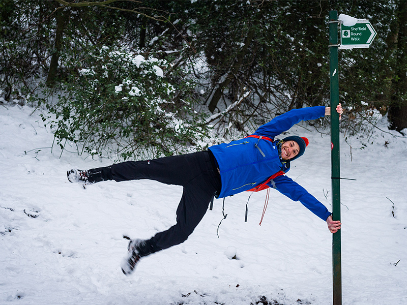 Rory swinging from a direction sign